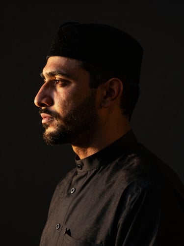 Low-key high-contrast portrait of Abdul Wahab Mir, cinematic lighting with deep shadows, sharp focus on a refined profile, dark obsidian background, warm golden-hour rim light.
