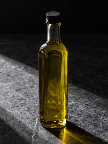 A high-end glass bottle of premium olive oil on a dark marble surface, dramatic side lighting casting long shadows, champagne gold highlights.