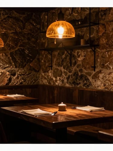 A cozy, dimly lit dining room corner in Barcelona, dark wood tables, amber hanging lamps casting a warm glow, rustic stone wall blended with modern iron accents, intimate atmosphere, 35mm lens