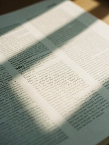 A close-up of a printed editorial layout on warm cream paper, soft natural daylight casting sharp architectural shadows, 35mm photography