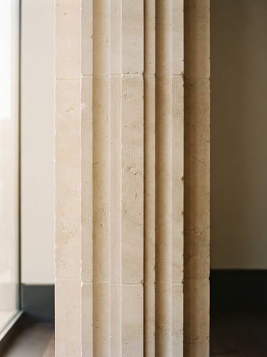 Elegant close-up of a structured architectural column in warm morning light, minimalist beige stone, clean lines, 35mm