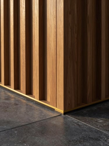 Architectural detail of custom woodwork meeting polished concrete floor, straight geometric lines, soft side lighting