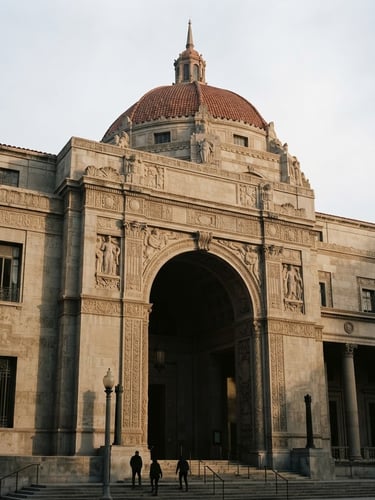 Low angle architectural shot of a classic stone library facade in Los Angeles, soft natural morning light, deep shadows, warm muted tones, 35mm film photography.