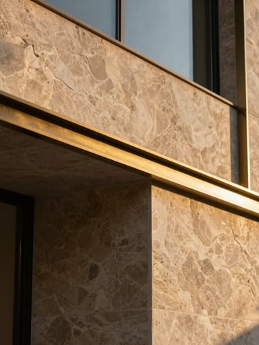 Extreme close-up of premium raw textured stone and polished brass detailing on a minimalist villa exterior, sharp geometric shadows, golden hour light