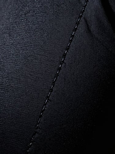 Macro detail shot of heavy-duty technical stitching on dark performance fabric, dramatic studio lighting, sharp highlights, deep shadows, 35mm film