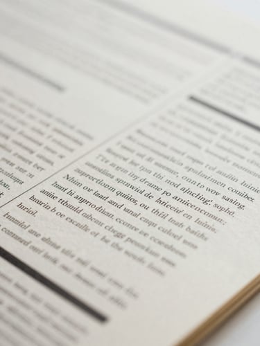 Macro close-up of a physical print layout on thick cream paper, black ink editorial markups, soft overcast London daylight, shallow depth of field
