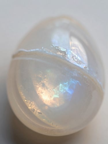 Soft-focus macro detail of a natural moonstone, pearlescent light reflecting off layered mineral planes, diffused morning light, dreamy editorial photography
