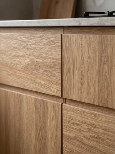 Close architectural view of a bespoke kitchen installation, oak cabinet fronts with flush reveals in north-facing daylight, grain texture sharp, seams barely visible