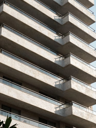 Modern architectural crop of a high-end residential building facade in São Paulo, clean lines, bright natural daylight with sharp geometric shadows.