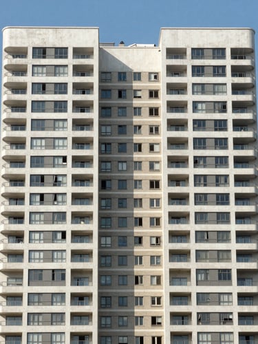 Symmetrical architectural crop of a modern high-rise residential building in São Paulo, clean lines, bright natural daylight, blue sky background.