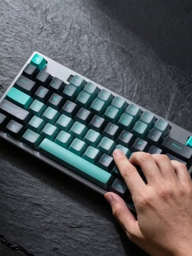 Overhead macro flatlay of a hand interacting with a sleek mechanical keyboard, cool studio lighting, sharp high-contrast shadows, dark slate background, neon teal accents, macro lens