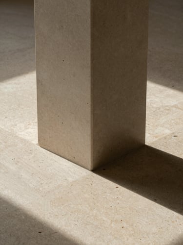 Symmetrical close-up of a structural column meeting a polished travertine floor, soft natural side light, architectural shadow lines, minimalist composition