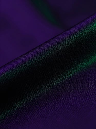 Macro shot of physical merchandise textures, high-contrast purple and green cyberpunk studio lighting, sharp fabric weave detail