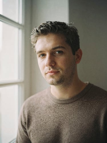 A candid, unposed portrait of Eugen Mîrtz in soft, natural window light, looking slightly away from the camera, warm earth tones, 35mm film style.