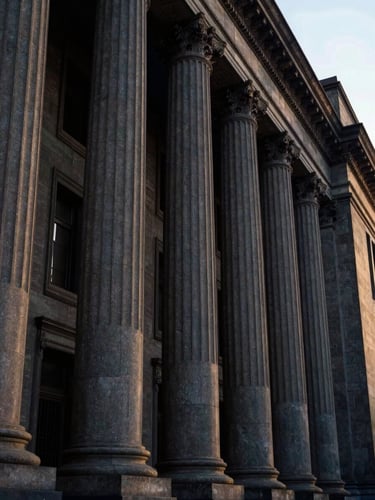 Low-angle architectural shot of the clean, imposing stone columns of a federal court in Mexico City, dramatic side-lighting, deep navy and gold tones, 35mm.