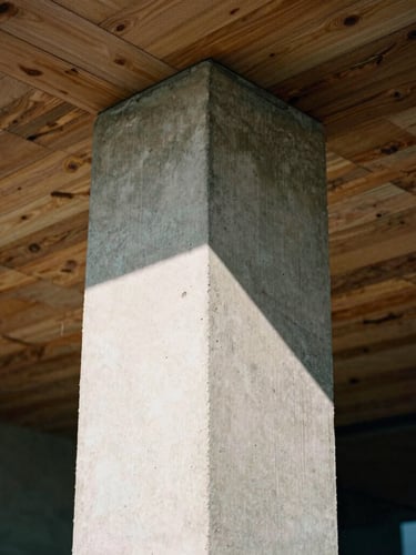 Tight geometric close-up of a raw concrete pillar meeting a rustic timber ceiling, sharp high-contrast daylight, architectural film photography style