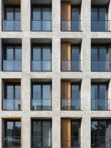 Straight-on architectural photograph of a modern concrete and glass apartment building exterior under bright morning daylight, sharp focus, 35mm