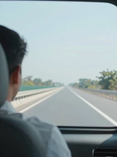 Over-the-shoulder view from the back seat of a clean, modern vehicle showing a clear Indian highway ahead, bright natural daylight, soft light blue tones, professional focus.