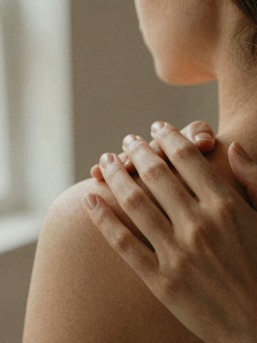 Close-up of warm hands gently resting on a shoulder, soft morning light, shallow depth of field, natural linen background, warm earth tones