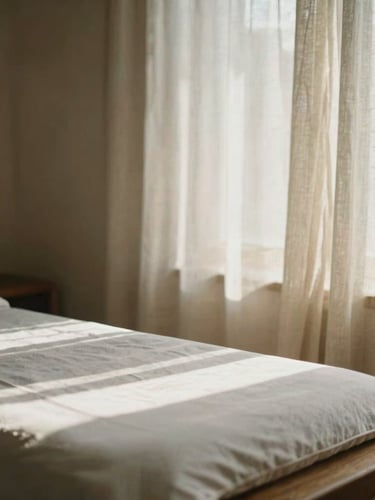 Quiet serene massage room with soft linen curtains, warm morning sunlight casting gentle shadows on a wooden table, editorial photography
