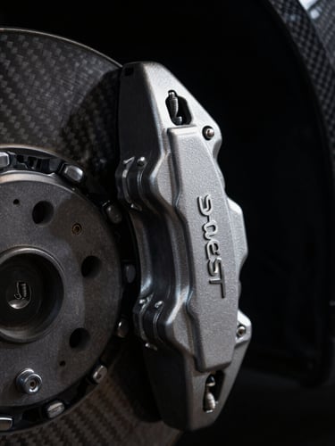 Macro close-up of a pristine metallic Peugeot brake caliper, dark carbon fiber background, dramatic low-key studio lighting with sharp silver rim highlights