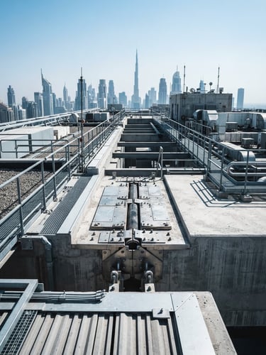 Sharp architectural photograph of a modern Dubai skyscraper rooftop, bright desert daylight, high-contrast cool tones, crisp focus on structural expansion joints.