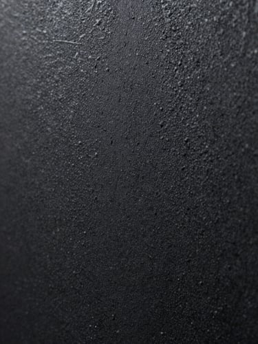 Macro close-up of a textured matte black powder-coated steel plate, dramatic directional lighting revealing the rugged physical grain