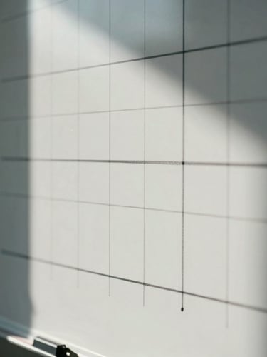 Extreme macro detail of a structured physical whiteboard with architectural grid lines, sharp daylight casting deep cool shadows, technical planning materials.