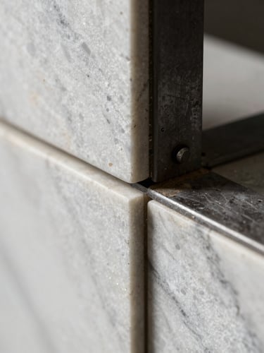 Extreme close-up of premium textured white marble and raw dark steel structural joint, sharp focus, dramatic high-contrast lighting, architectural detail