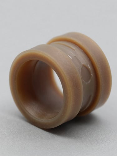 Macro studio photograph of a custom-machined elastomer seal profile with clean geometric cross-section, sharp lighting highlighting technical tolerances