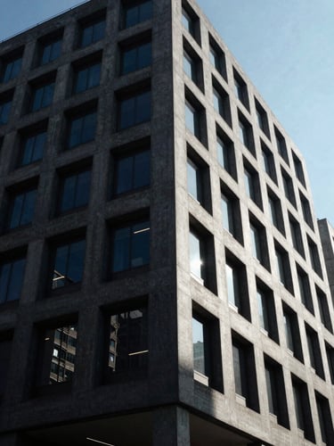 Low-angle architectural shot of brutalist corporate office building, sharp concrete shadows, high-contrast daylight, deep navy tones, editorial corporate photography