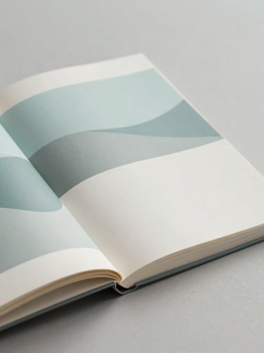 Minimalist editorial book layout, open pages showing abstract flowing graphics in soft cyan and mist gray, soft side light