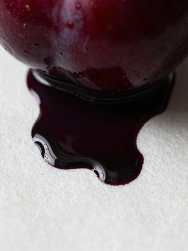 Extreme macro photograph of dark plum ink bleeding into heavy white cotton paper, high-contrast chiaroscuro lighting, visible paper fibers and rich paint ridges.