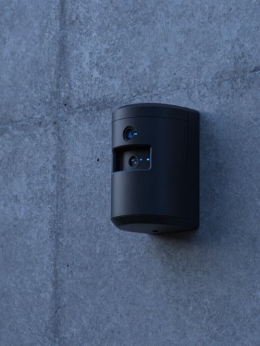 Close-up of a matte black security sensor seamlessly embedded in a raw concrete wall of a luxury villa, twilight blue hour lighting, sharp focus, 35mm.