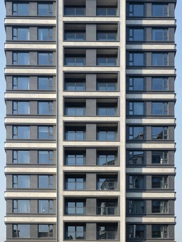 Straight-on architectural elevation of a sunlit modern residential high-rise, crisp morning daylight, focus on clean structural lines.