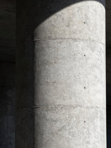 Stark industrial photography, portrait shot of a massive raw concrete pillar under high-contrast direct sunlight, sharp focus, 35mm lens