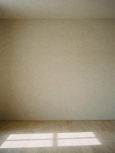 A minimalist, quiet treatment room with natural linen, soft indirect light casting low-contrast shadows, architectural details of the serene space, 35mm film