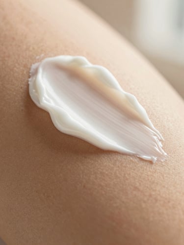 Makroaufnahme einer reichhaltigen, samtigen weißen Creme-Textur, die sanft über die Haut gestrichen wird, warmes goldenes Licht, geringe Tiefenschärfe, taktile Premium-Beauty-Fotografie