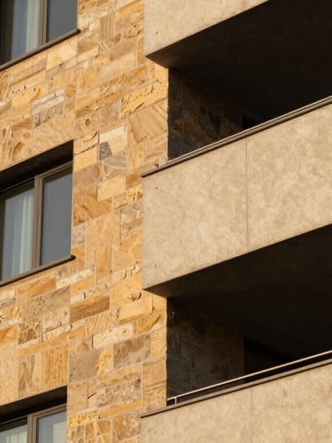 Tight, geometric detail shot of warm sandstone and concrete exterior of a modern condo at golden hour, sharp shadows.