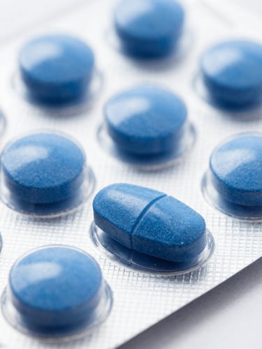 Macro close-up of dry oral tablets in a clean white blister pack, bright clinical studio lighting, deep blue tones, sharp 50mm focus