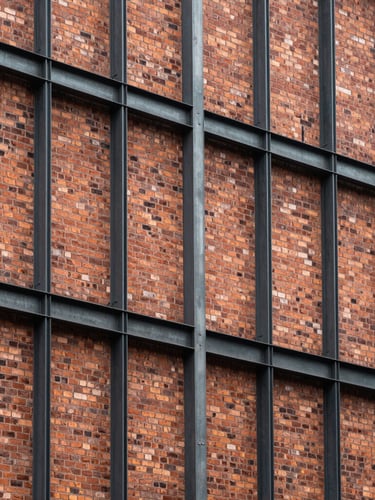 Vertical architectural shot of a modern steel frame retrofitted into a historic brick facade, clean straight lines, raw steel meeting weathered clay.