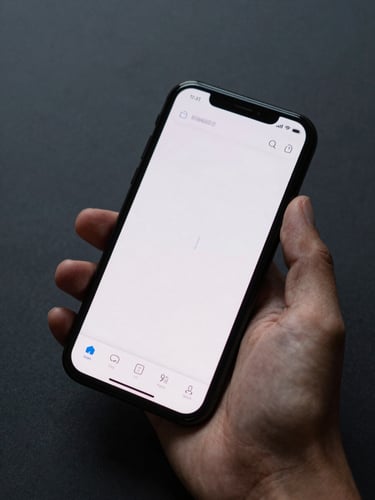 Close-up of a smartphone held in a hand against a deep charcoal surface, the screen showing a clean minimal navigation interface with route and fuel markers, soft studio ambient light, precise and calm