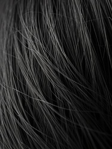 Dramatic low-key macro photography of fine organic hair fibers, sharp texture details, deep shadows, high-contrast monochrome.