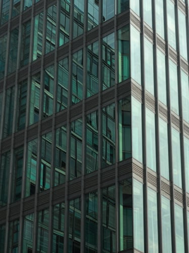 Sharp geometric crop of modern glass office facade in Dhaka, bright natural daylight, high-contrast structural green reflections, 35mm