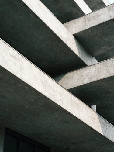 Tight geometric crop of concrete and steel architectural lines, sharp shadows, clean daylight, architectural framing, 35mm