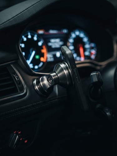 Macro shot of a brushed alloy magnetic mount inside a modern car cockpit, dramatic dashboard instrument glow, shallow depth of field.