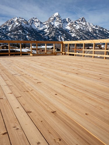 Wide shot of a heavy timber deck under construction against the Tetons, crisp winter sun, raw wood grain visible