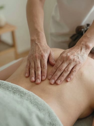 Close-up of respectful, gentle massage hands on a mature shoulder, warm ambient indoor lamplight, soft textiles, shallow depth of field