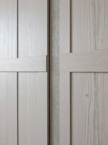 Macro photograph of a premium material junction showing white oak paneling meeting a raw concrete column, soft diffused daylight, sharp focus.