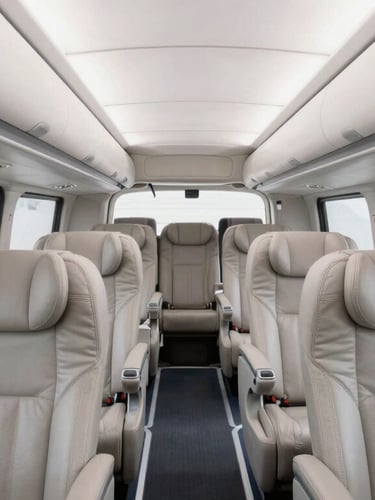 Interior cabin of a luxury coach showing spacious leather seating, ample legroom, and spotless cabin standards, bright natural daylight, wide-angle lens